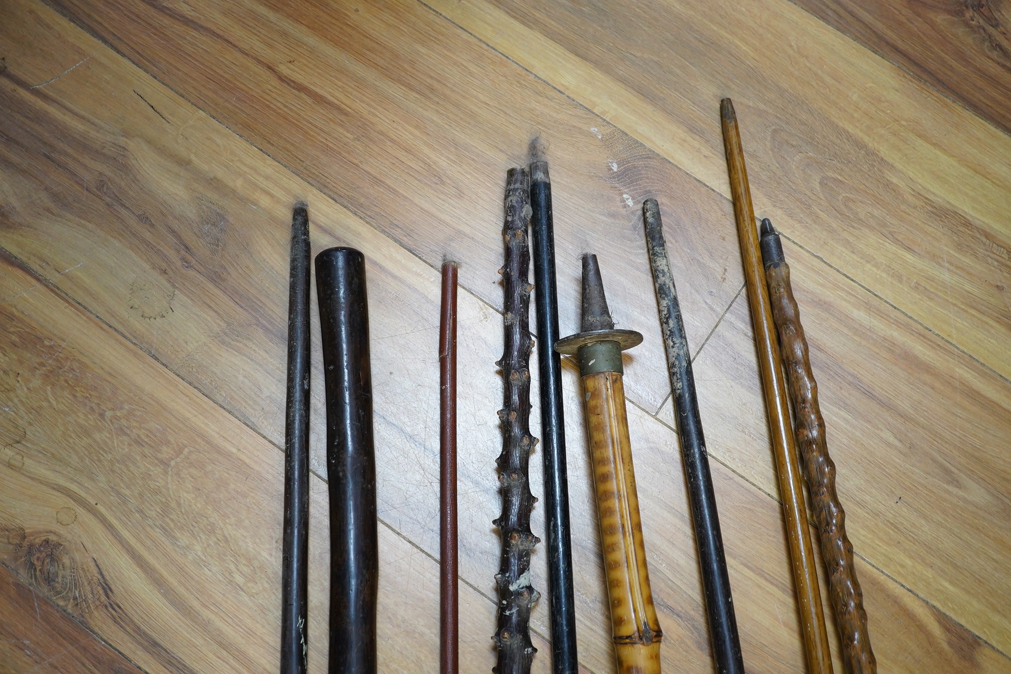 An Edwardian oak stickstand and sundry walking sticks including a bamboo shooting stick, silver topped cane etc. condition varies